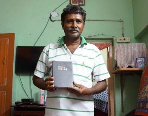Raju holds his new Bible, joyful to have found the Gospel.